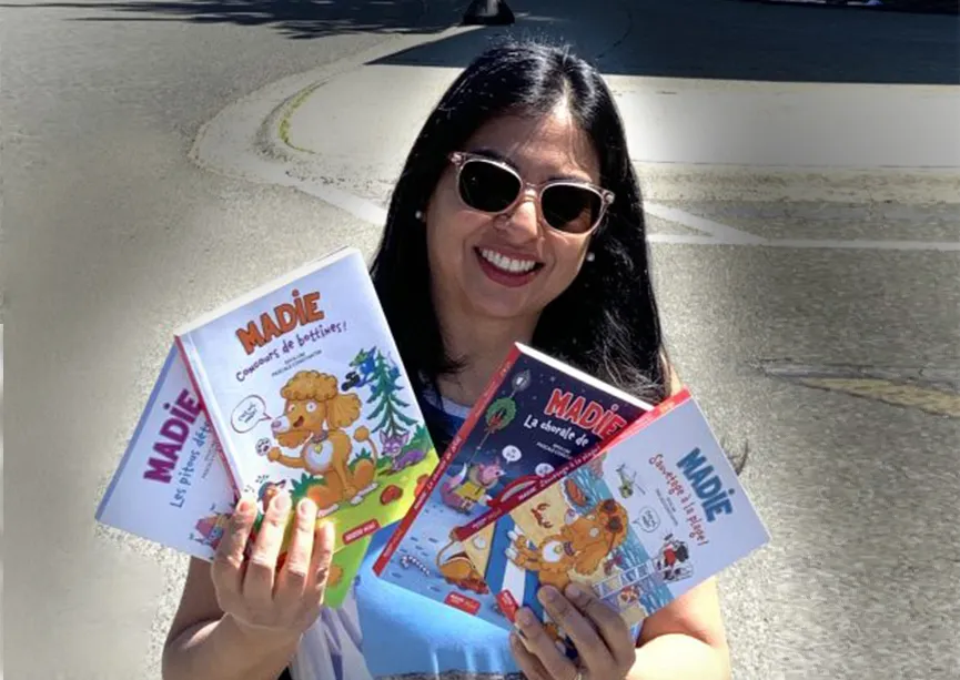 Diya Lim tenant quatre différents tomes de sa série Madie.